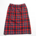 a red, green, and navy plaid vintage high-waisted midi skirt on a white background.